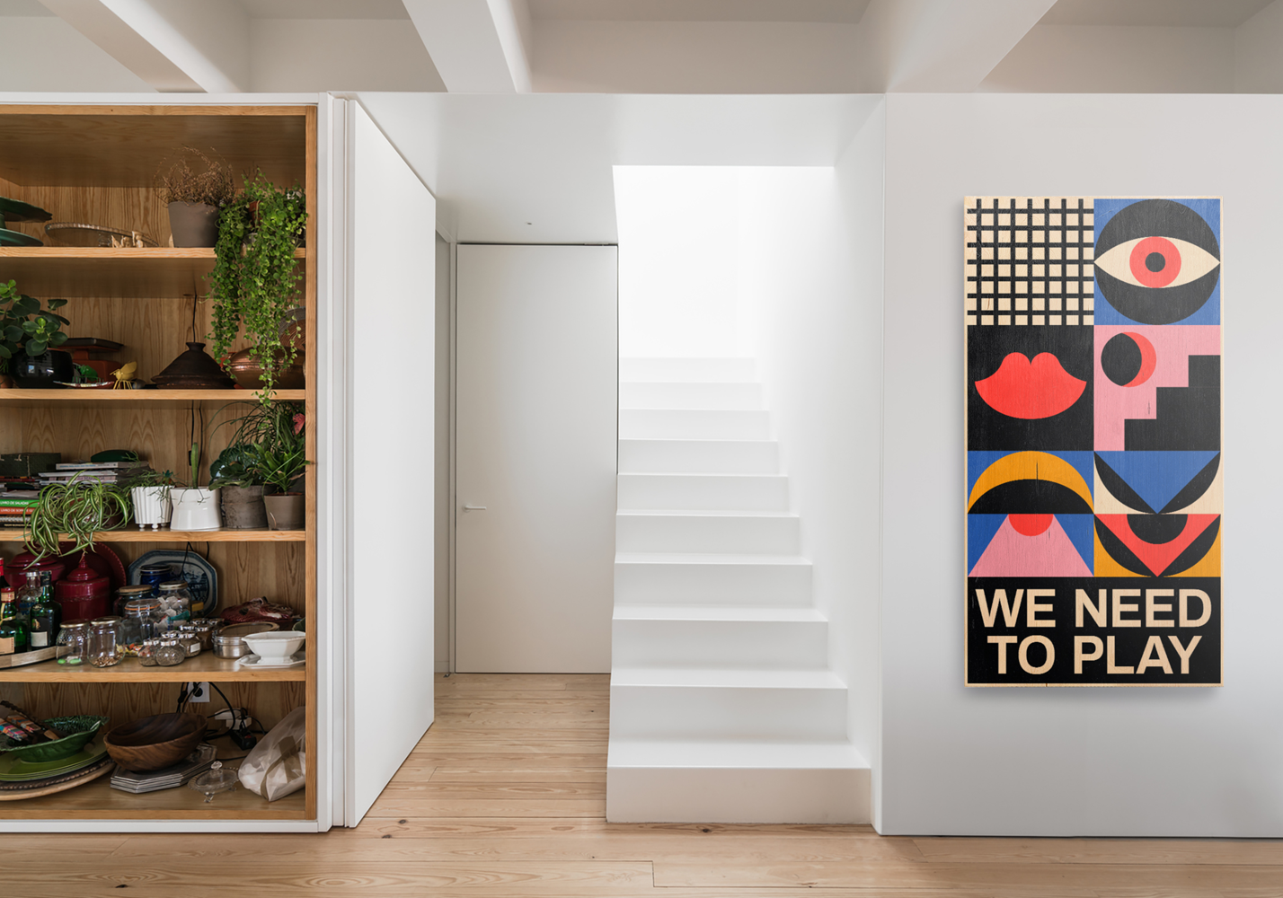 Love You ArtTable by Kelly Anna mounted on a white-painted wall in a modern home interior with wooden flooring, open shelving, plants and a minimalist staircase.