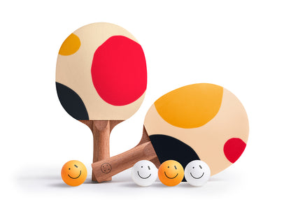 Two colorful ping pong paddles with smiley face balls on a white background